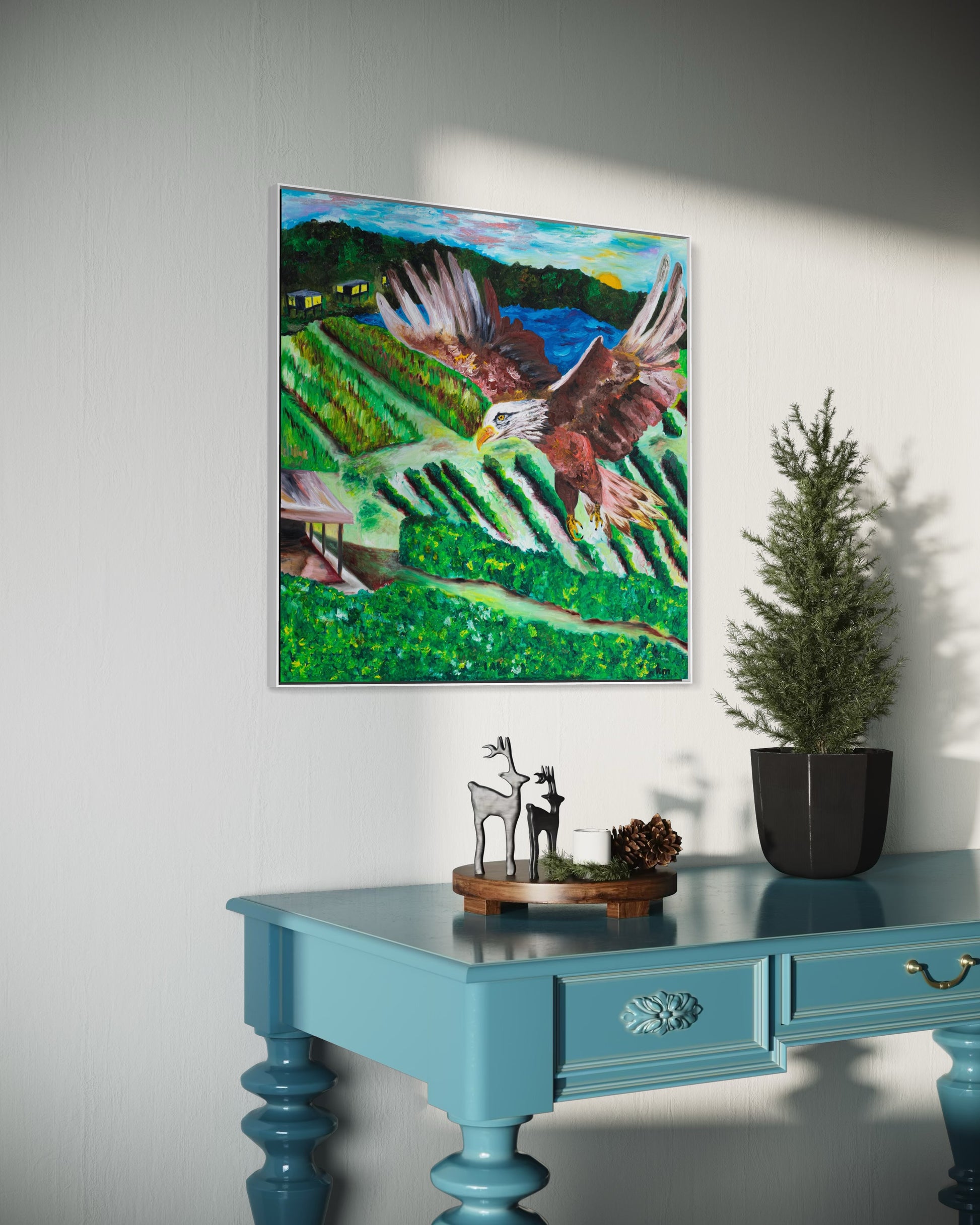 Rise Above It All - Framed canvas option - Christian inspirational faith art by Art By Kudzi  
Framed painting of a bird over a landscape on a white wall above a blue table with decorative items.
